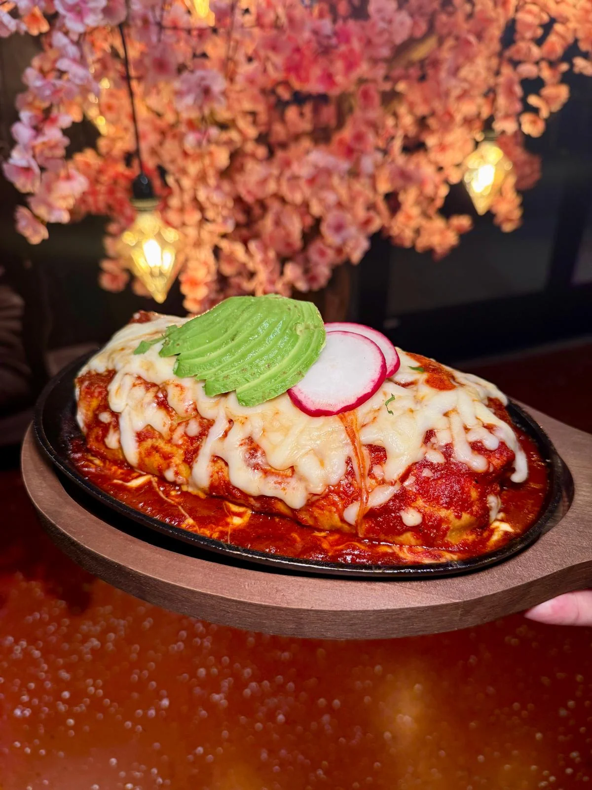 Jalapeños Burrito Skillet topped with red salsa, melted cheese, avocado and radish