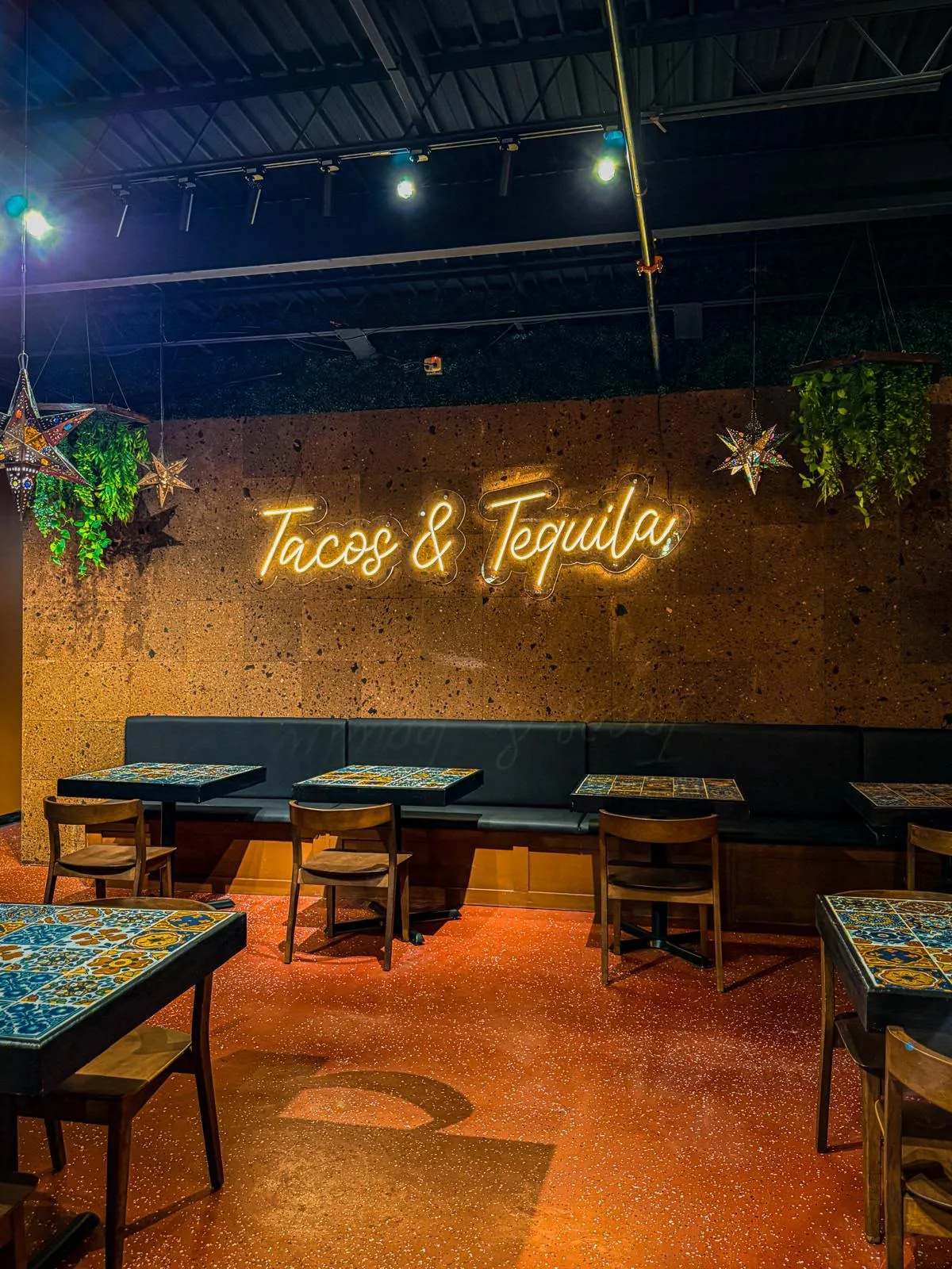 Tacos & Tequila neon sign above tiled dining tables at Jalapeños in Lubbock